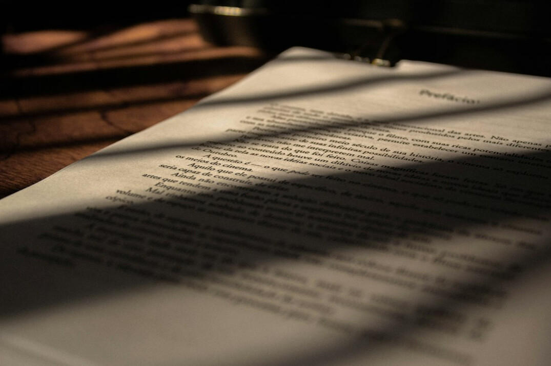 Stack of documents with a magnifying glass on a desk